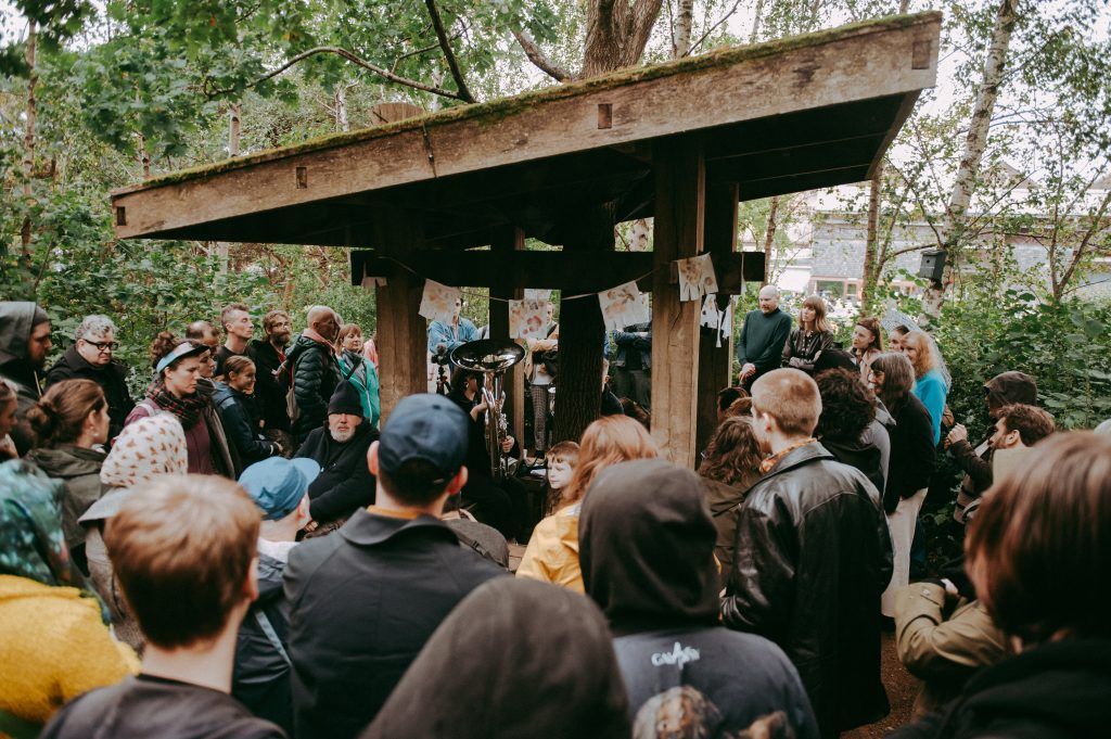 A crowd of people surrounding a wooden structure.